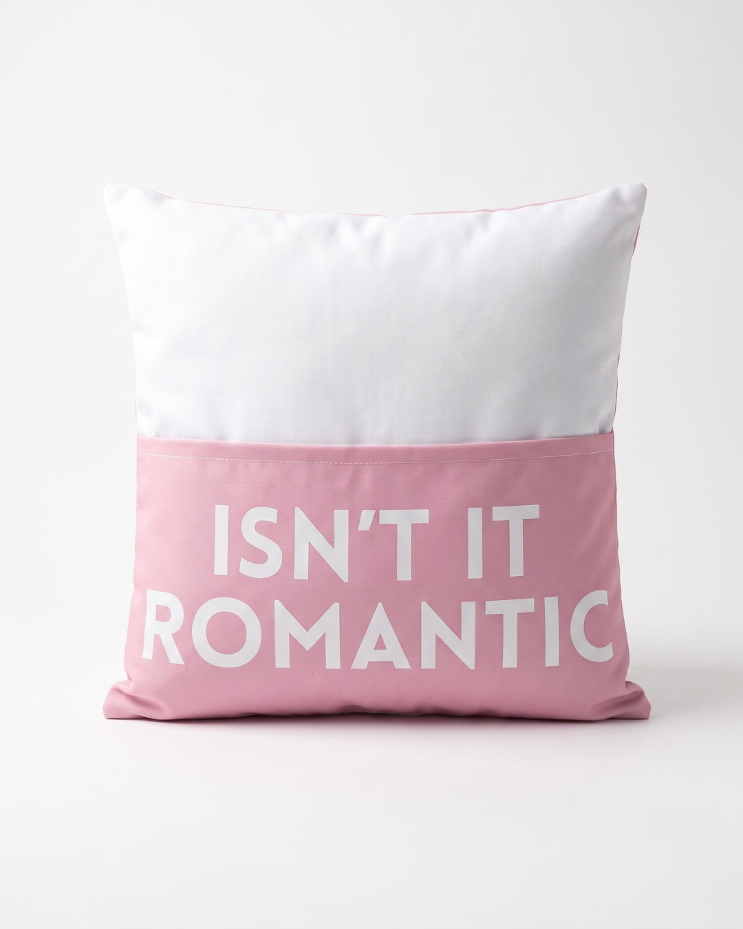 Pink and white decorative cushion cover featuring the phrase "Isn't It Romantic" on the pocket on the front