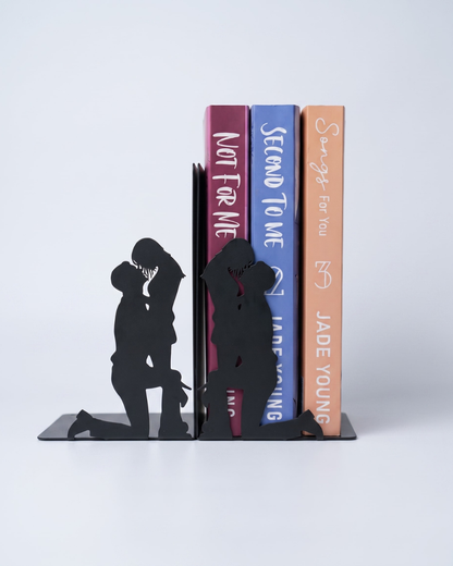 Black metal romantic couple silhouette bookends supporting a collection of romance novels on the side.
