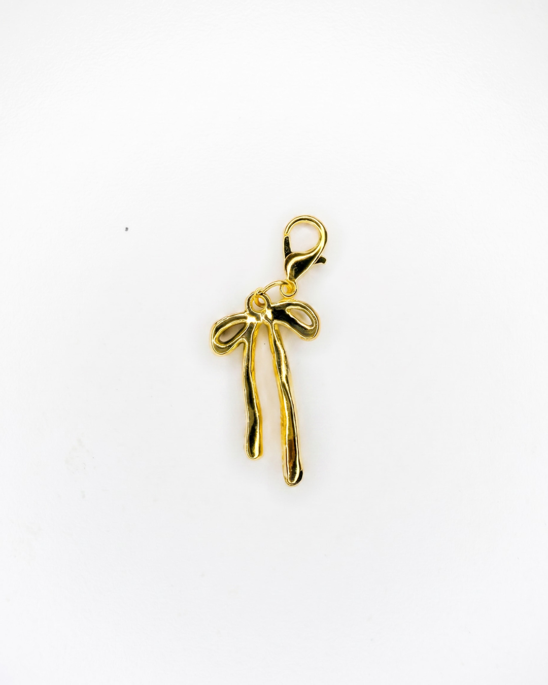 Golden charm with lobster hook showing a thick golden bow