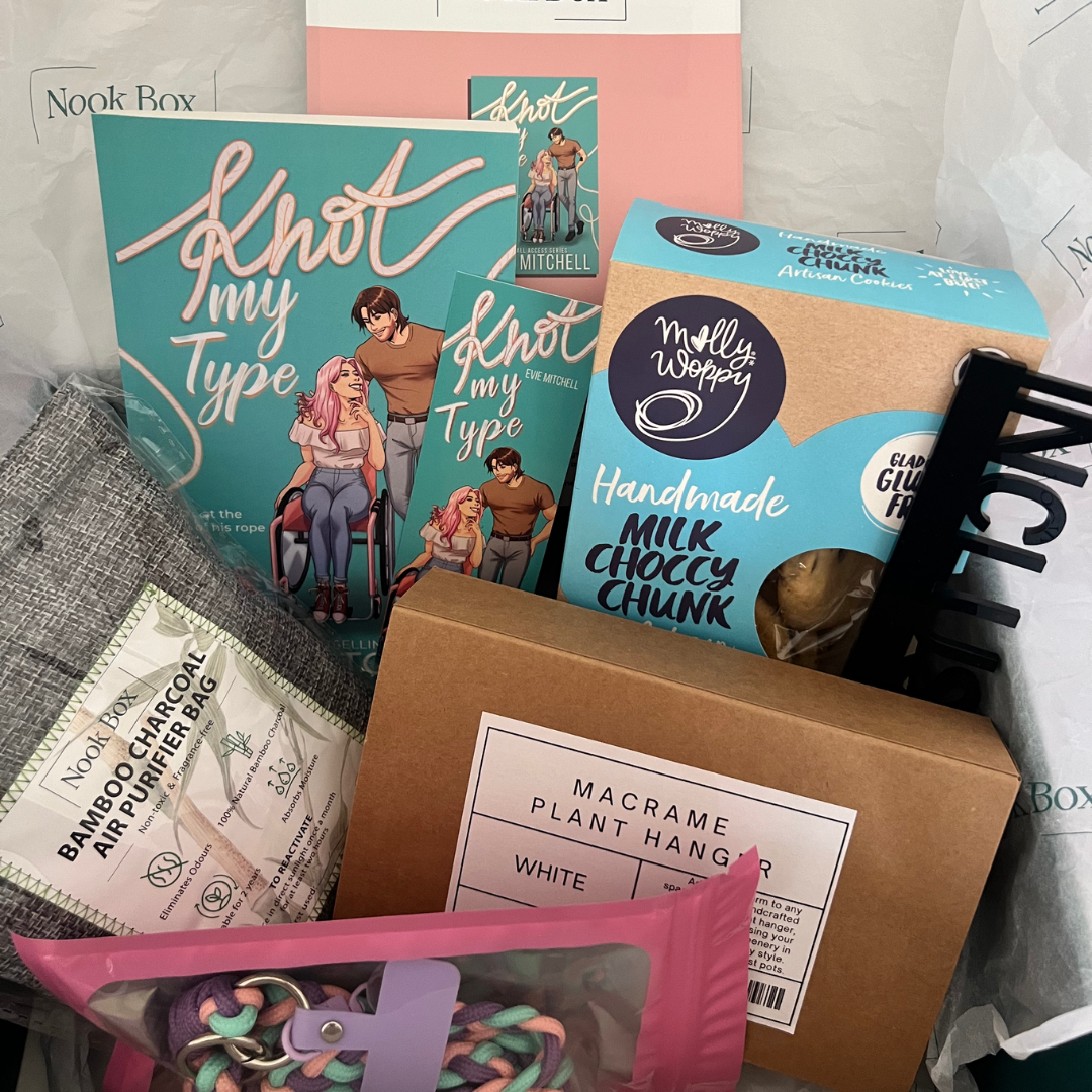 July 2025 Nook Box featuring Knot My Type by Evie Mitchell with macrame plant hanger, bamboo charcoal dehumidifier, cookies and bookish accessories.