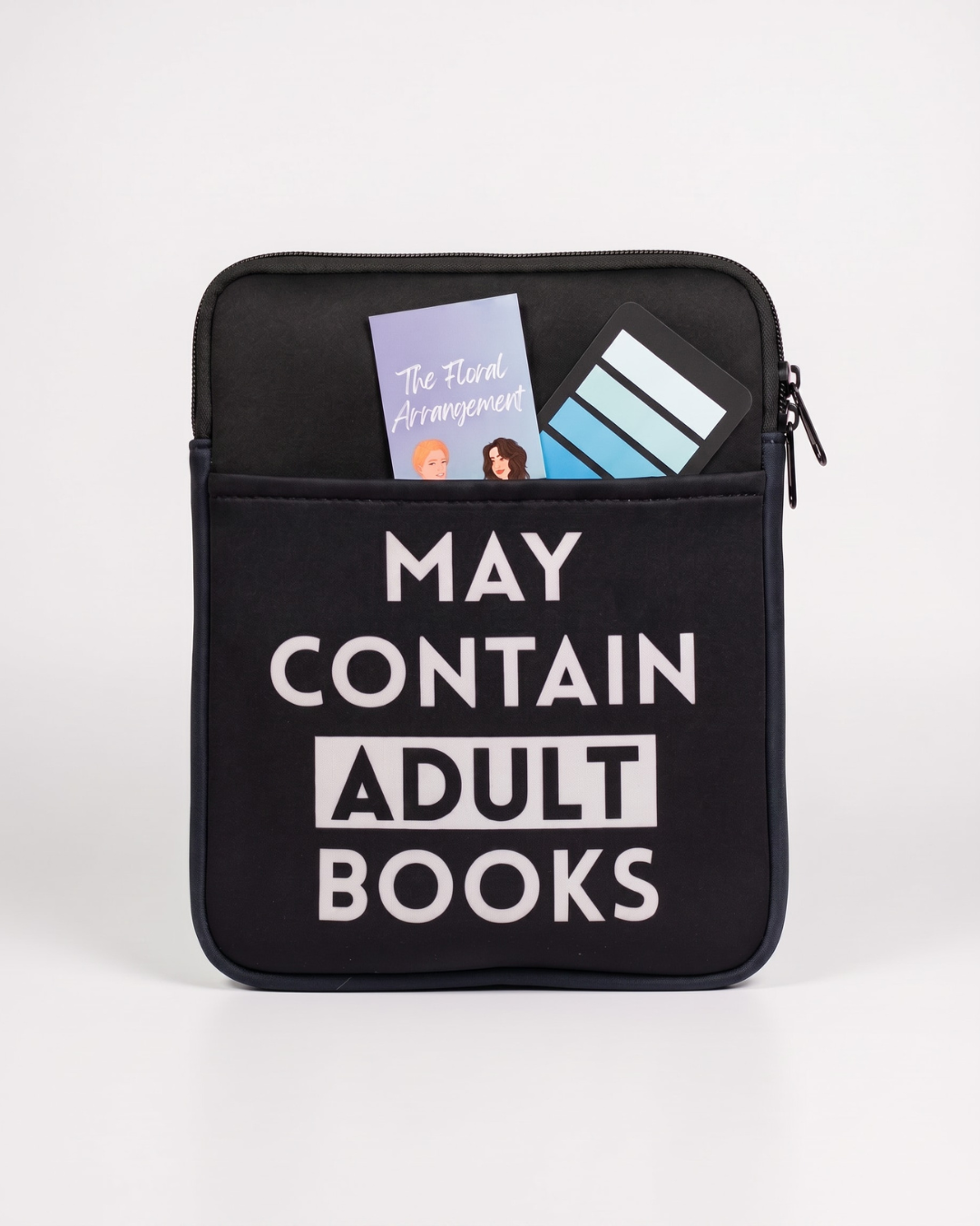 Black padded book sleeve printed with "May Contain Adult Books" for protecting books and eReaders while travelling. items showcase the pocket on front