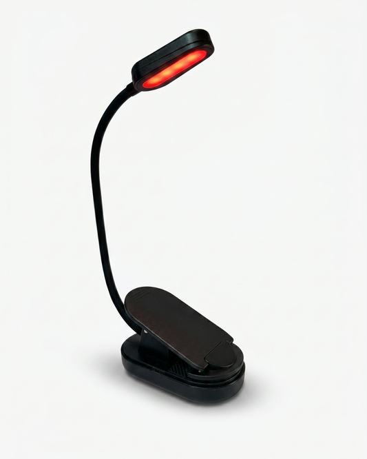 Black clip-on rechargeable reading light with adjustable flexible neck and red LED illumination angled downward for reading in bed.