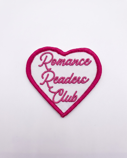 a white heart shape patch with pink boards, in the heart the text says 'Romance Readers Club'